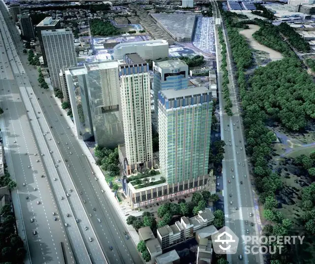 Aerial view of modern high-rise buildings in urban setting with lush greenery and highway access.