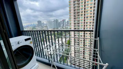 High-rise balcony with washing machine and city view, perfect for urban living.