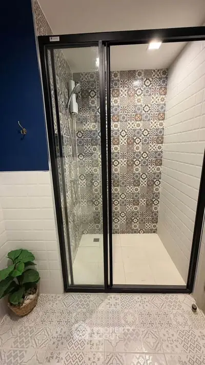 Stylish bathroom with patterned tiles and modern shower enclosure