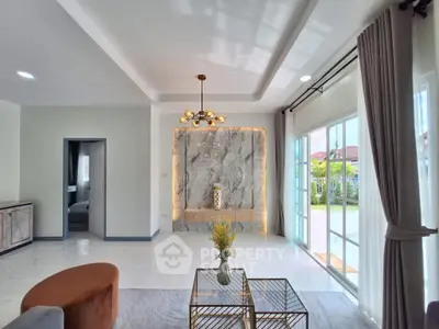 Modern living room with elegant lighting and large windows opening to garden view.