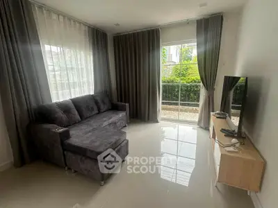 Modern living room with sleek sofa and large window overlooking garden