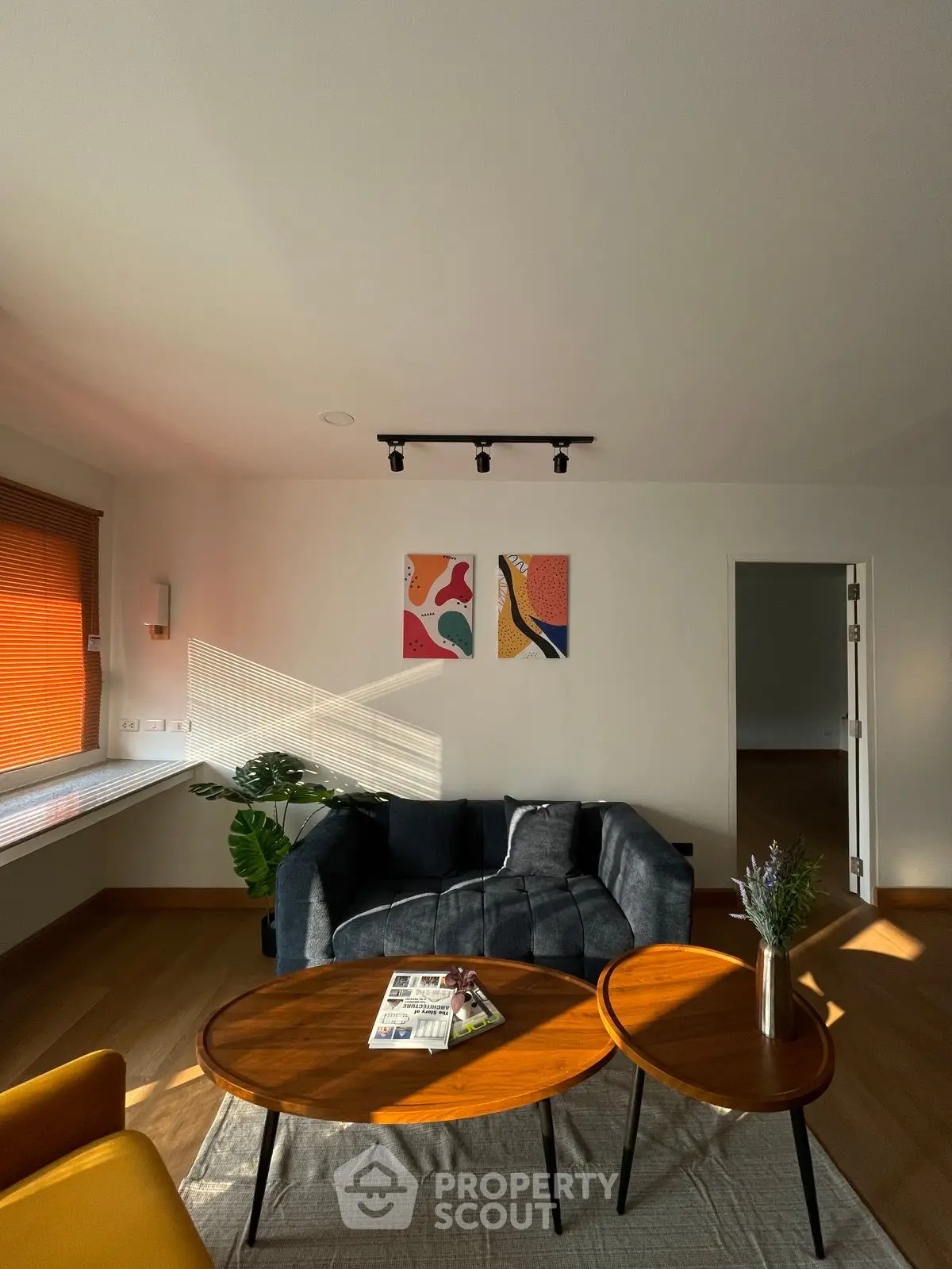 Stylish living room with modern furniture and artistic wall decor, featuring natural light and cozy ambiance.