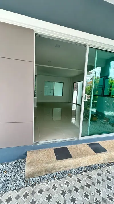 Modern open-plan living space with sliding glass doors and tiled flooring