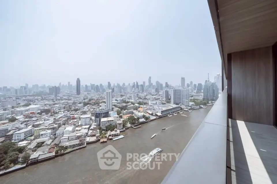 Stunning high-rise view of city skyline and river from a modern balcony.