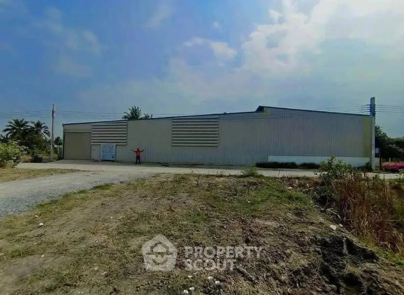 Expansive industrial warehouse with ample outdoor space and clear blue sky.