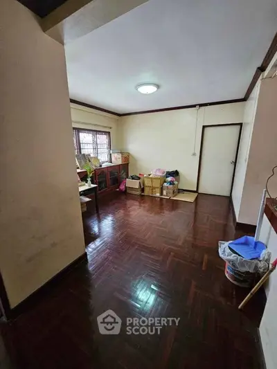 Spacious room with wooden flooring and ample natural light, ideal for versatile living arrangements.