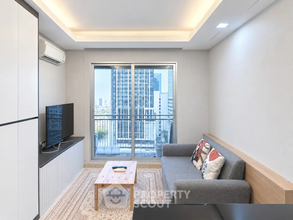 Modern living room with city view, featuring sleek furniture and large windows.