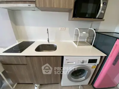 Modern kitchen with built-in appliances, featuring a washing machine and microwave for convenient living.