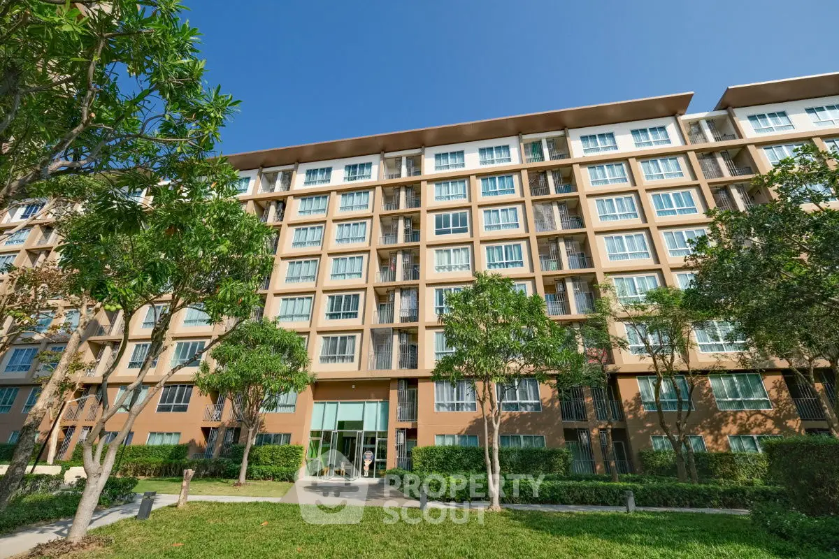 Modern apartment building with lush greenery and clear blue sky