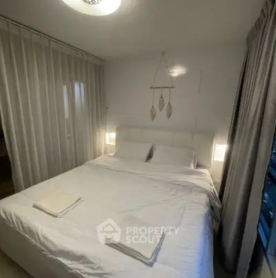 Cozy bedroom with modern decor and soft lighting, featuring a comfortable bed and elegant curtains.