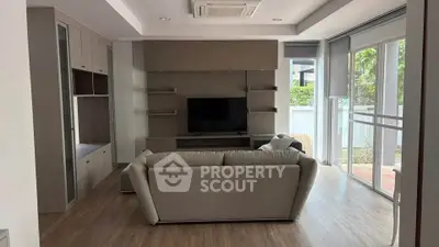 Modern living room with sleek furniture and large windows offering natural light.