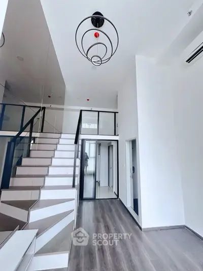 Modern duplex interior with sleek staircase and high ceilings