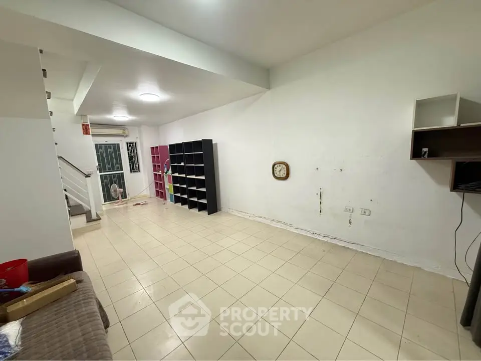 Spacious living room with tiled flooring and built-in shelving, ideal for modern living.