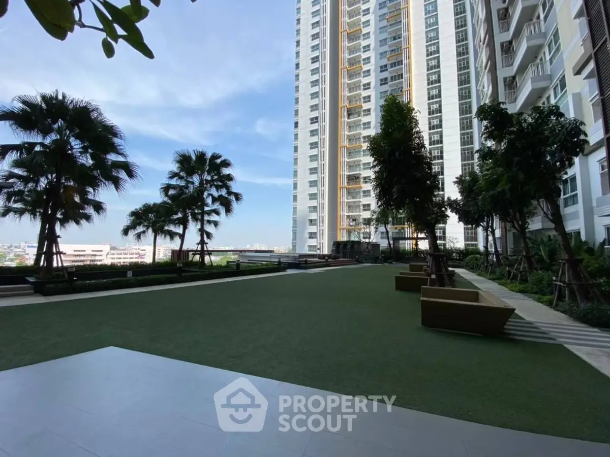 Luxurious high-rise building with lush garden and stunning city views.