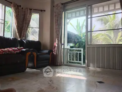 Spacious living room with large windows and tropical garden view