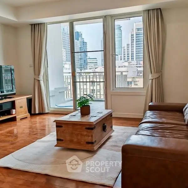 Spacious living room with city view, leather sofa, and wooden coffee table.