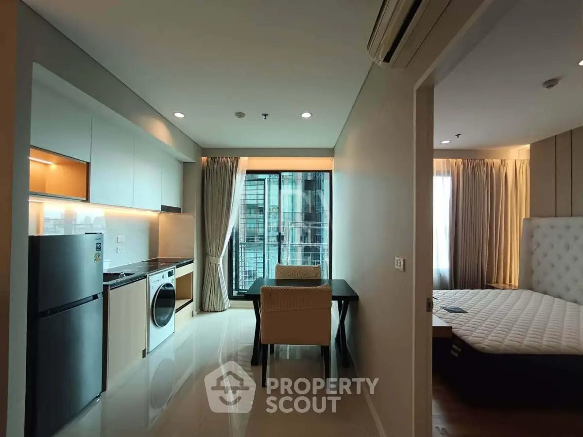 Modern apartment interior with kitchen, dining area, and bedroom featuring large windows and natural light.