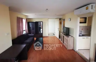 Spacious living room with modern furniture and open kitchen layout in a cozy apartment.
