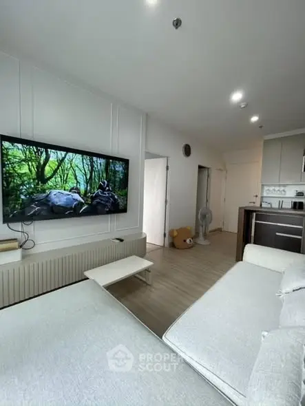 Modern living room with large TV and cozy seating area