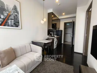 Modern living room with compact kitchen and stylish decor in urban apartment.