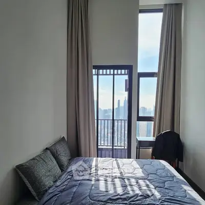 Modern bedroom with city view and tall windows, perfect for urban living.