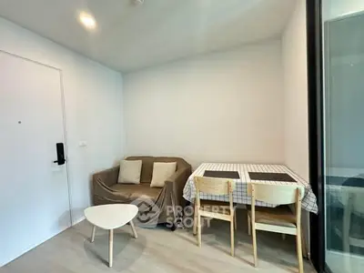 Cozy living room with modern furniture and dining area in a compact apartment.