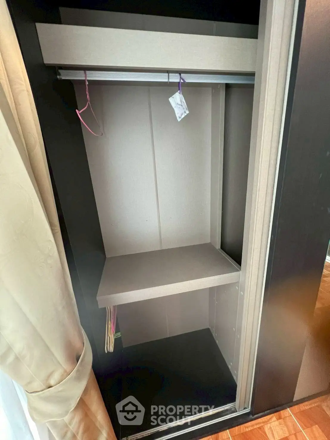 Spacious built-in closet with hanging rod and shelf, perfect for organized storage in modern homes.