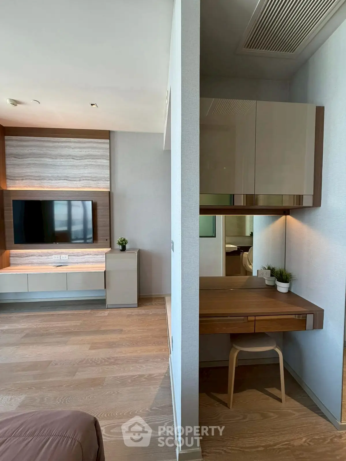 Modern living room with built-in TV unit and cozy study nook, featuring elegant wood flooring and contemporary decor.