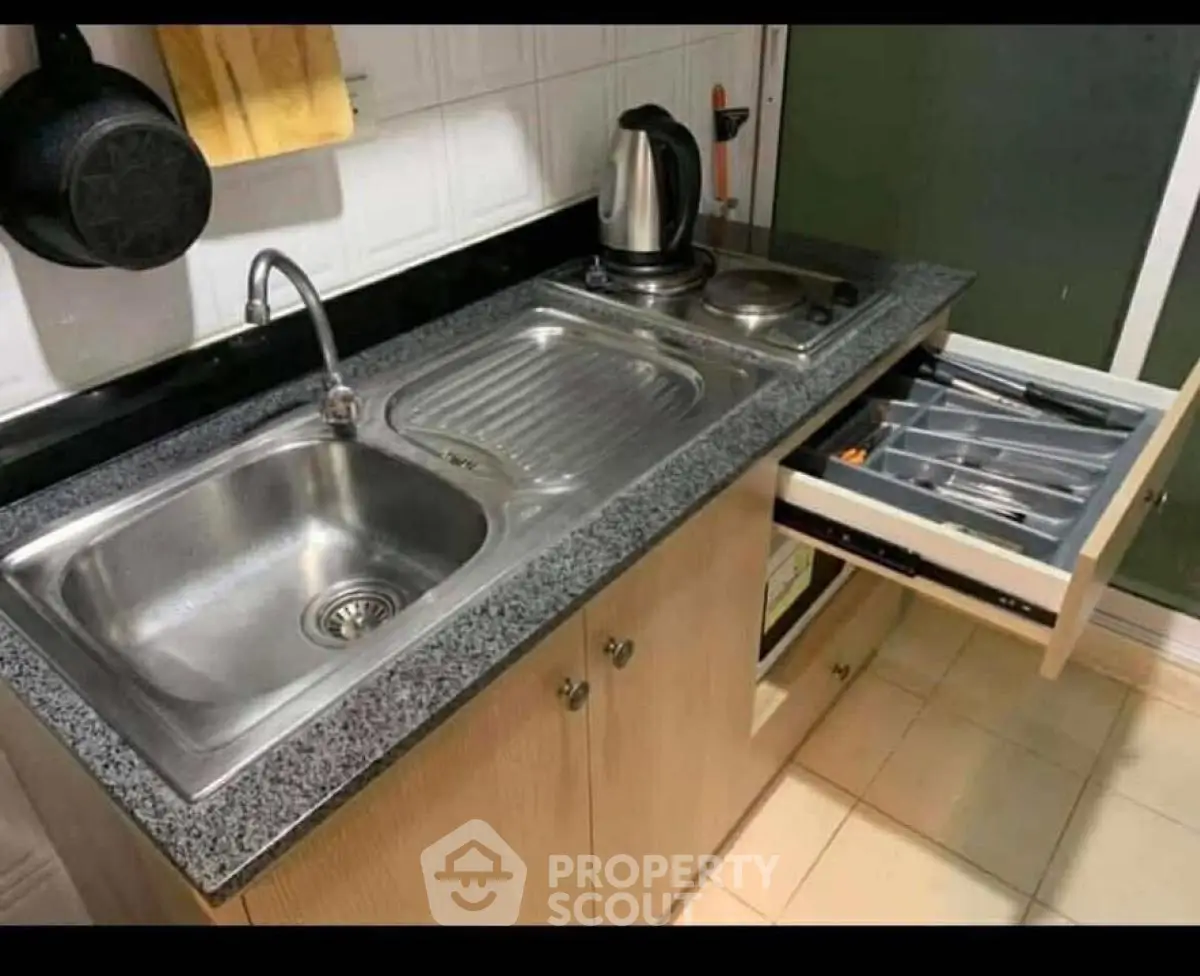 Compact kitchen with stainless steel sink and electric stove