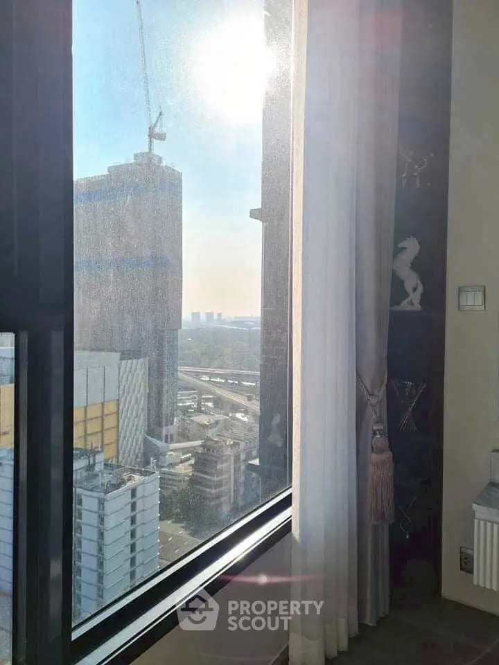 Stunning cityscape view from a high-rise apartment window with modern interior decor.