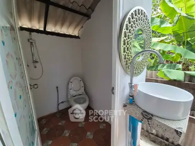 Charming rustic bathroom with outdoor view, featuring a modern sink and shower area, perfect for nature lovers.