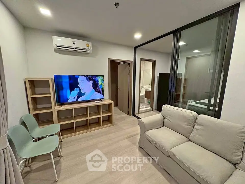Modern living room with sleek furniture and large TV, perfect for relaxation and entertainment.