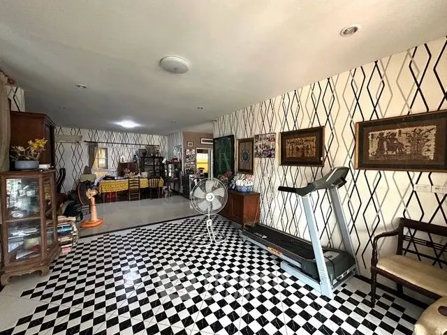 Spacious living room with unique checkered flooring and treadmill, perfect for relaxation and exercise.