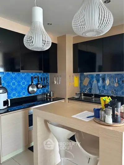 Modern kitchen with stylish lighting and blue backsplash