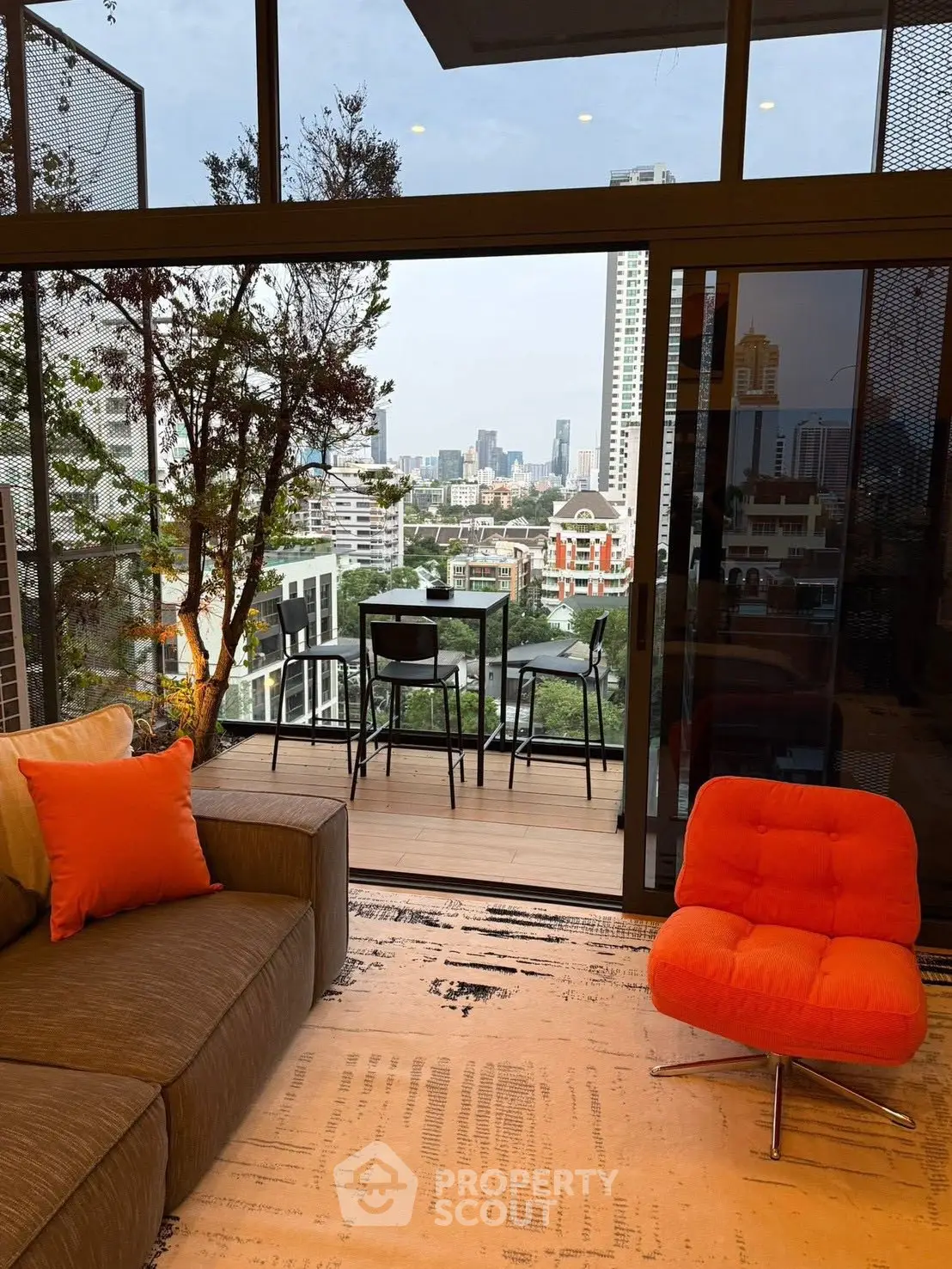 Modern living room with balcony offering stunning city view and stylish furniture.