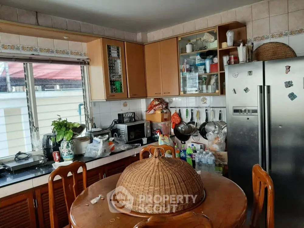 Cozy kitchen with wooden cabinets and modern appliances, perfect for family gatherings.