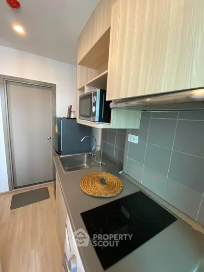 Modern kitchen with sleek appliances and stylish cabinetry in a contemporary apartment.