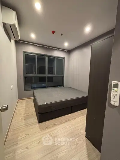 Modern bedroom with large window and minimalist design in a stylish apartment.