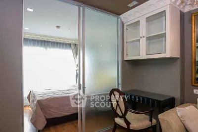 Elegant bedroom with glass partition and stylish decor, featuring natural light and modern furnishings.