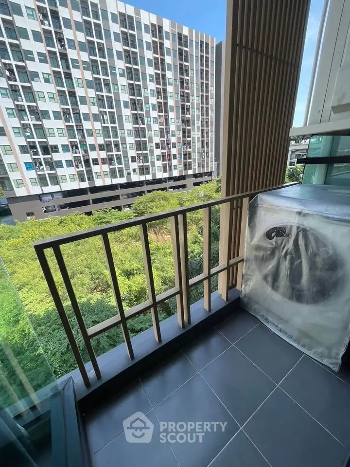 Modern balcony with city view and greenery, featuring sleek railing design.