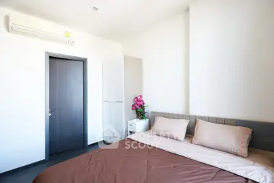 Modern bedroom with sleek design and air conditioning, featuring a cozy bed and minimalist decor.