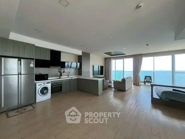 Spacious open-plan living room with ocean view, modern kitchen, and elegant furnishings.