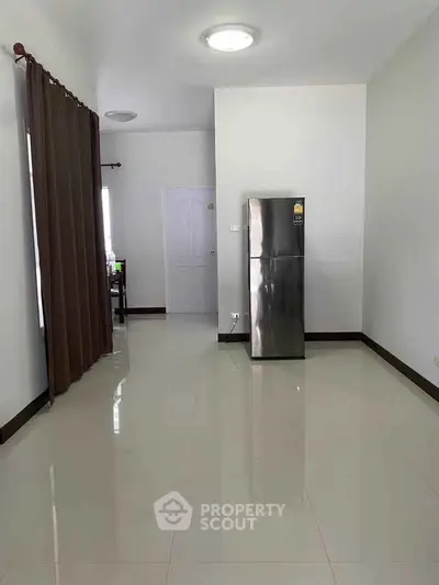 Spacious interior with modern refrigerator and sleek tile flooring