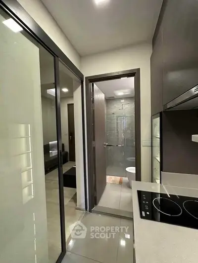Modern compact kitchen with sleek design and adjacent bathroom