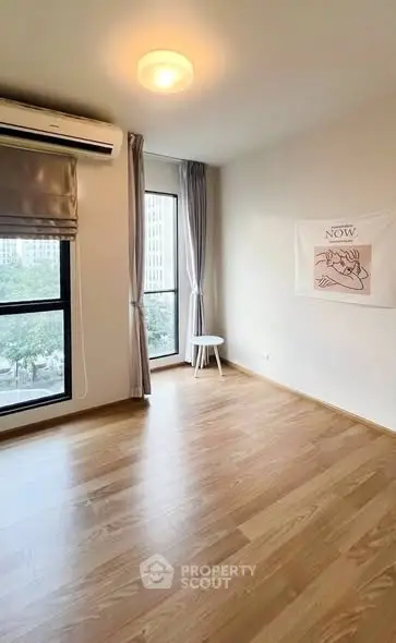 Bright and airy bedroom with large window and modern flooring