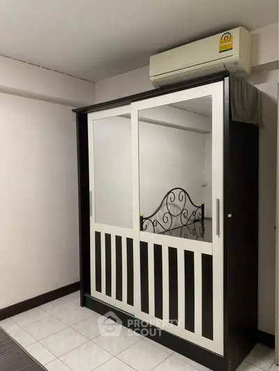 Spacious bedroom with mirrored wardrobe and air conditioning unit, perfect for modern living.