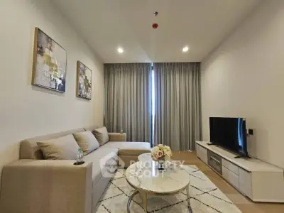 Modern living room with stylish decor, featuring a cozy sofa, elegant coffee table, and flat-screen TV.