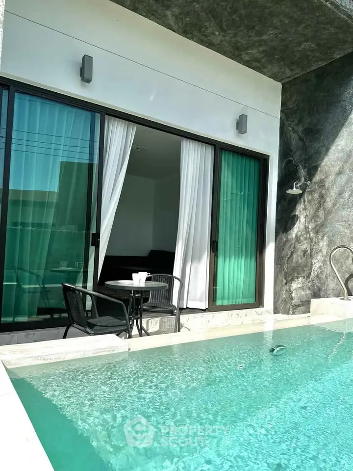 Luxurious poolside view with modern sliding glass doors and elegant outdoor seating.