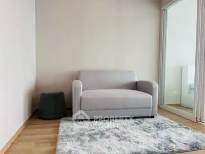 Cozy living room with modern gray sofa and plush rug in stylish apartment.