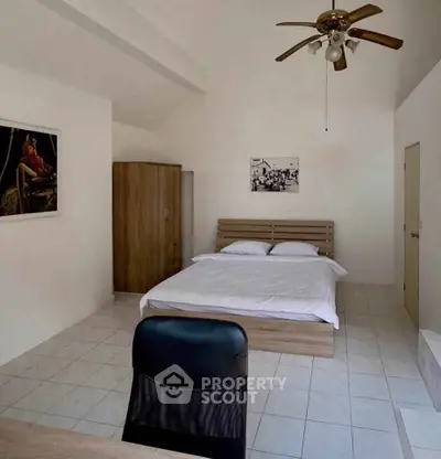 Spacious bedroom with modern furnishings and ceiling fan, ideal for comfort and relaxation.